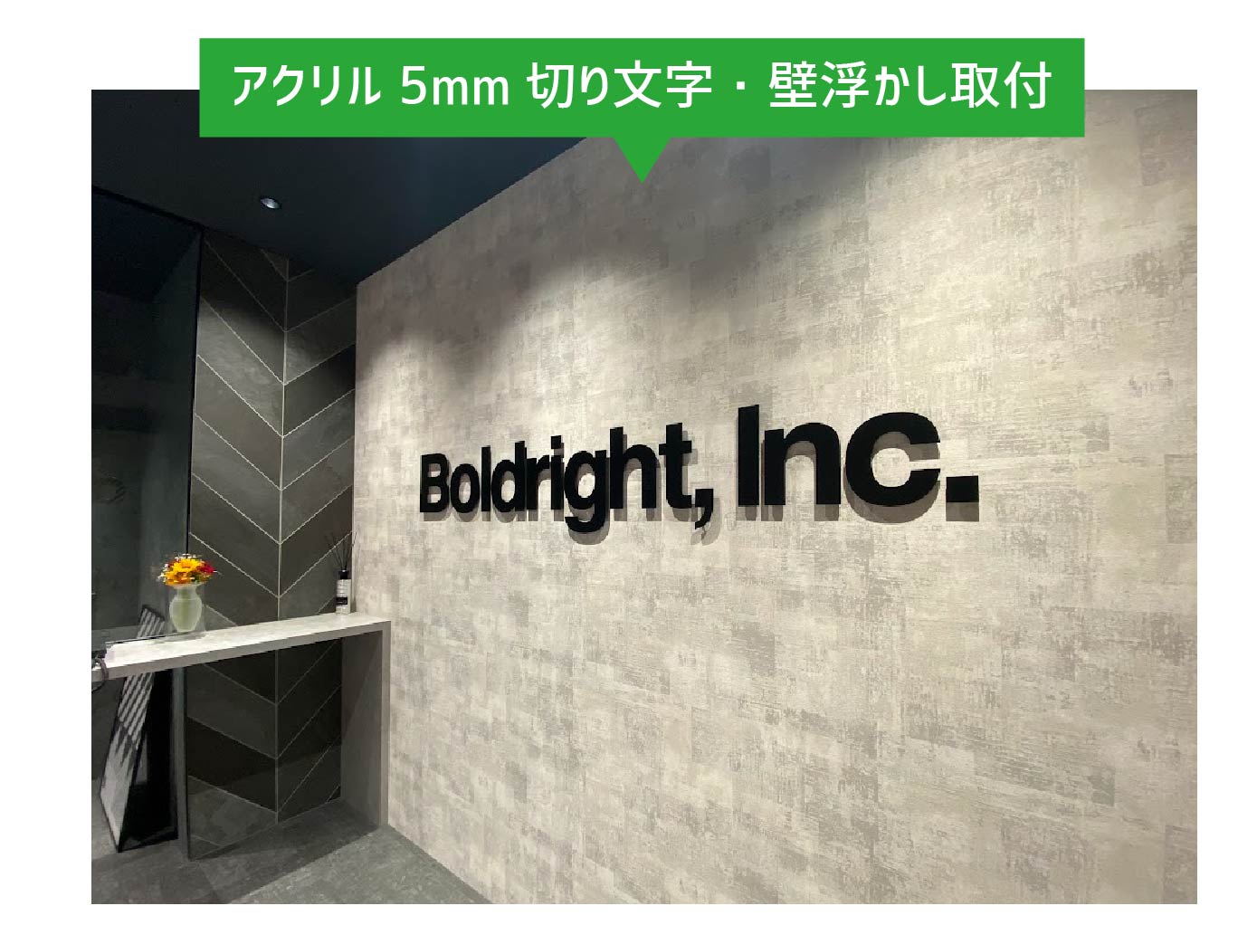 オフィスの壁面に設置された黒のアクリル切り文字看板。ピンでの浮かし付け施工により立体感を出したおしゃれな社名サインの事例。